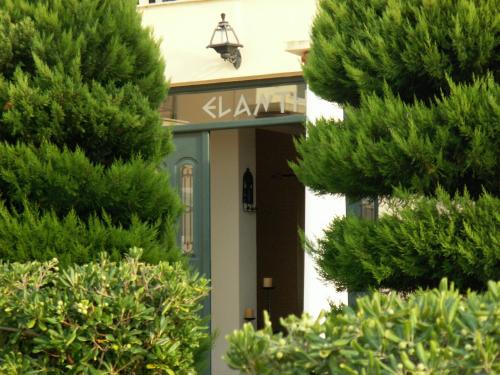 a building with a sign that reads akhtar at Elanthi Village Apartments in Kalamaki