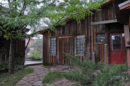 a wooden house with a red door and trees at Creekside Cowa-Bungalow! in Moab