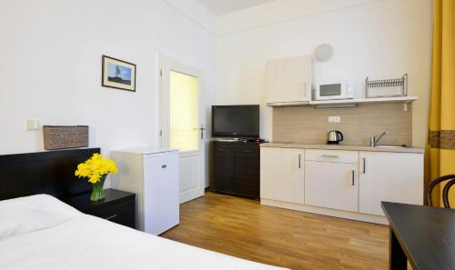 a room with a bed and a kitchen with a table at Apartments Central Park Marienbad in Mariánské Lázně