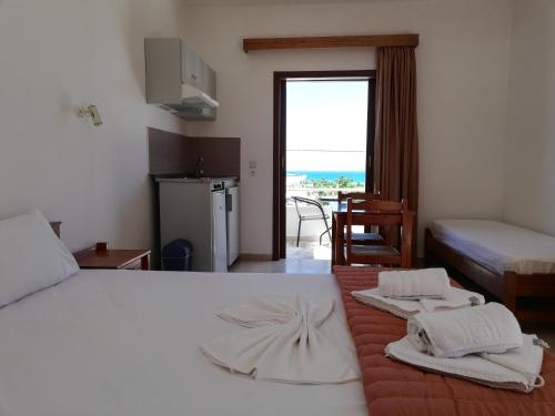 una camera da letto con un letto con due asciugamani sopra di Karmi Apartments a Kolymvari