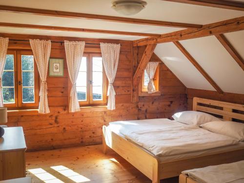 a bedroom with a bed in a room with wooden walls at Chalupa Lužické hory in Dolní Světlá