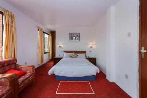 una camera da letto con un letto e un divano di Pacific Guest House a Kathmandu