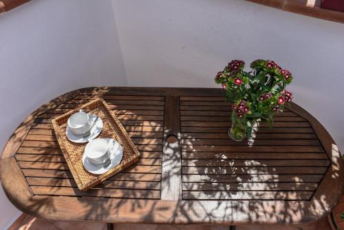 a table with a plate and a vase of flowers at Rooms 19 B&B in Palermo