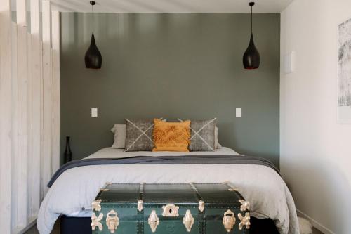 a bedroom with a bed with a green trunk at Three Streams Raglan Retreat in Raglan