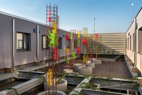 a group of potted plants on the side of a building at Holiday Inn - the niu, Hide Berlin Friedrichshain by IHG in Berlin