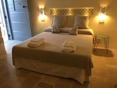a bedroom with a large bed with towels on it at Masseria Capece in Cisternino