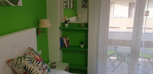 a green room with a bed and a green wall at ele&gio accomodation in Tropea