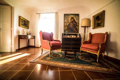 a living room with two chairs and a rug at Palazzo Pulieri in Altino