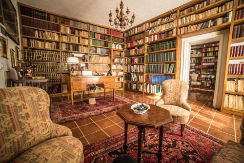 a library with bookshelves and a table and chairs at Palazzo Pulieri in Altino
