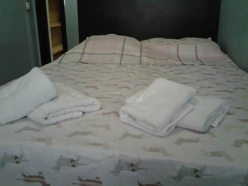 a bed with white towels on top of it at Old Tbilisi Flavor for You in Tbilisi City