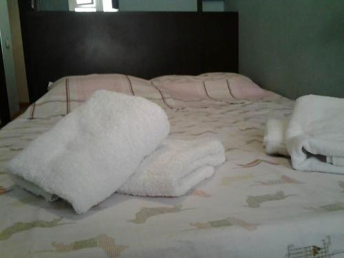 a bed with white towels on top of it at Old Tbilisi Flavor for You in Tbilisi City