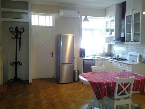 a kitchen with a table and a stainless steel refrigerator at Old Tbilisi Flavor for You in Tbilisi City