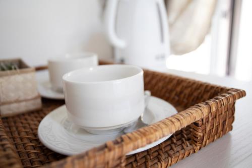un panier avec deux tasses et des assiettes sur une table dans l'établissement Rooms 19 B&B, à Palerme