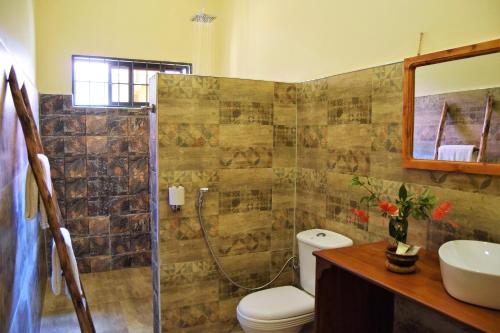 a bathroom with a shower and a toilet and a sink at Chanya Lodge in Moshi