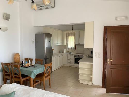 a kitchen with a table and chairs and a refrigerator at Krinakia Villas in Xerokampos
