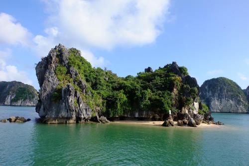 a small island in the water next to a beach at Cat Ba Bay Cruises in Cat Ba