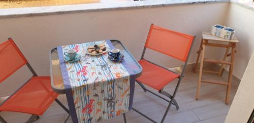 a table and two chairs with a plate of food on it at ele&gio accomodation in Tropea