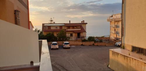 two cars parked in a parking lot in front of a building at ele&gio accomodation in Tropea