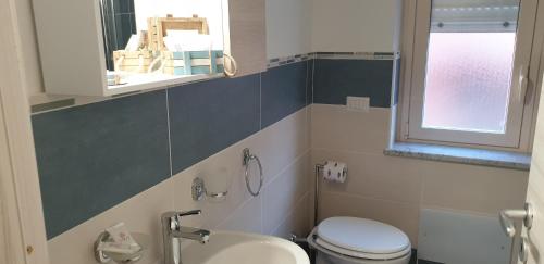 a bathroom with a toilet and a sink and a window at ele&gio accomodation in Tropea