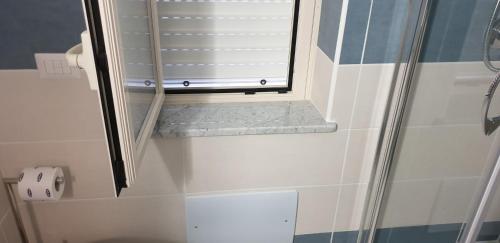 a bathroom with a shower with a window and a toilet at ele&gio accomodation in Tropea