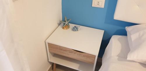 a white night stand next to a bed at ele&gio accomodation in Tropea