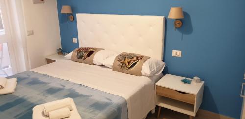 a bedroom with a large bed with a blue wall at ele&gio accomodation in Tropea