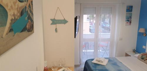 a bedroom with a bed and a door to a balcony at ele&gio accomodation in Tropea