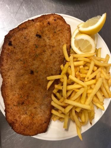 a plate of food with a piece of fish and french fries at Agriturismo Regusci in Camorino