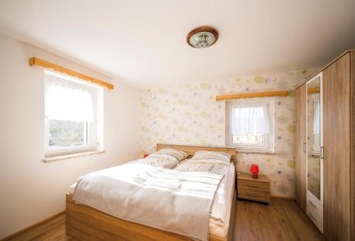 1 dormitorio con 1 cama y reloj en la pared en Ferienwohnung am Bauernhof, en Oederan