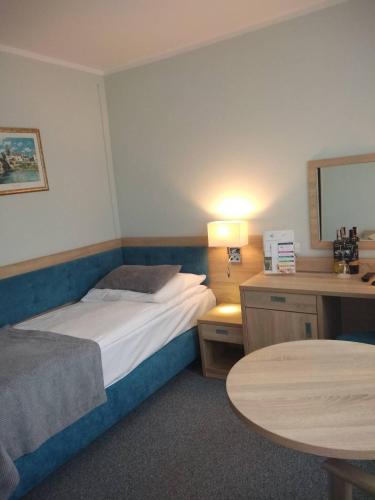 a hotel room with a bed and a table at Hotel ***NAT Świnoujście in Świnoujście