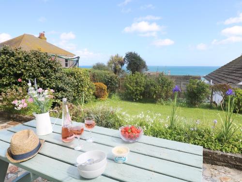 a picnic table with a bottle of wine and fruit at Wootton Gray in Mousehole