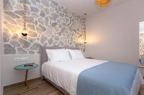 a bedroom with a bed and a stone wall at Rapanos Apartments in Paleokastritsa