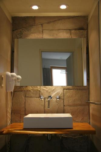 a bathroom with a sink and a mirror at Galileo Boutique Hotel in San Carlos de Bariloche
