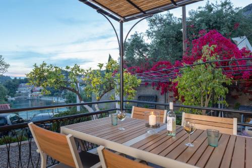 a wooden table on a balcony with flowers at Rapanos Apartments in Paleokastritsa