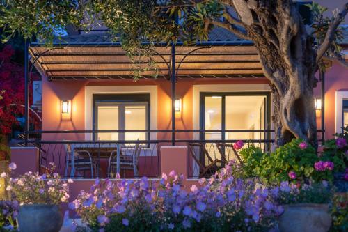 a house with flowers in front of it at Rapanos Apartments in Paleokastritsa