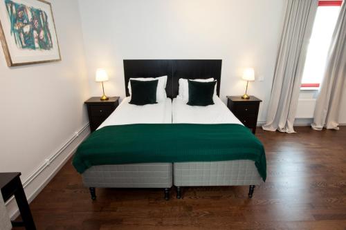 ein Schlafzimmer mit einem großen Bett und einer grünen Decke in der Unterkunft Rasta Götene in Götene