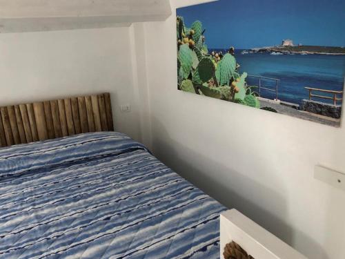 a bedroom with a bed and a painting on the wall at La casetta di Portopalo in Portopalo