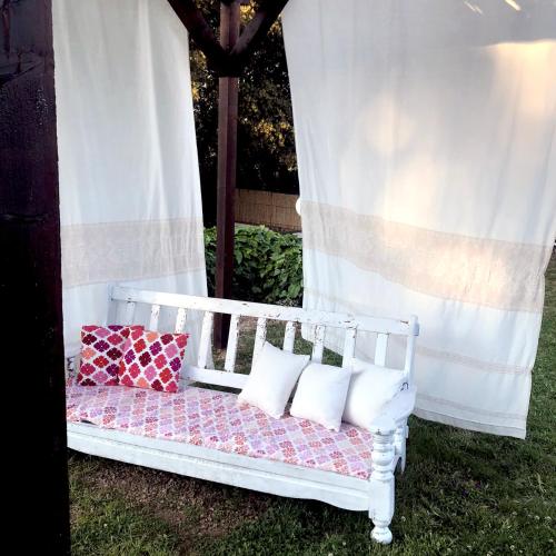 a white bed with pillows sitting on the grass at B&B La Tasgia in Aggius