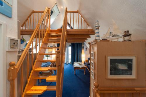 a room with a wooden staircase in a house at Ferienwohnungen Reetwinkel in Wieck in Wieck