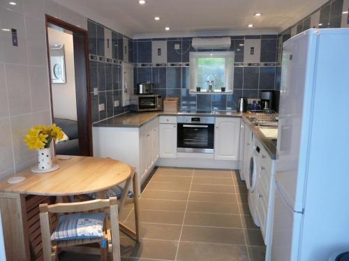 a kitchen with a table and a refrigerator at The Keep Pot in Port Isaac