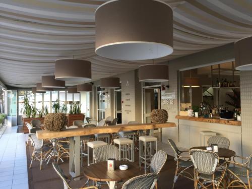 restauracja ze stołami i krzesłami oraz bar w obiekcie Hotel Arena w mieście Lido di Jesolo