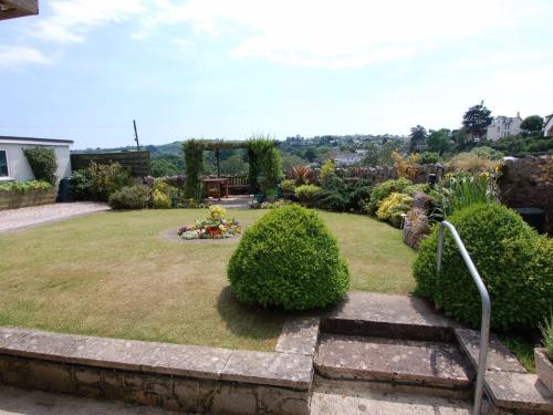 a garden with a lawn with bushes and trees at Garden View in Kingskerswell