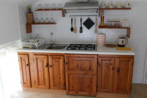 una cucina con armadi in legno e lavandino di Fruit'n Joy a Stresa