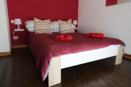 a bedroom with a large bed with a red wall at Fruit'n Joy in Stresa