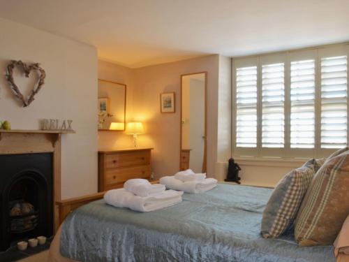 1 dormitorio con toallas en una cama con chimenea en Lakeside, en Millbrook