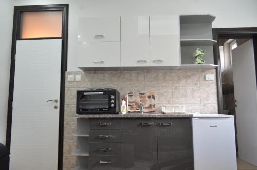 a kitchen with white cabinets and a microwave at Apartments Sokolović in Višegrad