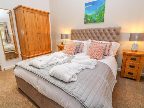 a bedroom with a large bed with towels on it at 1 Lake View in Looe