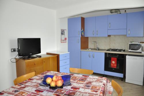uma cozinha com uma mesa com uma taça de fruta em Casa Tania em Pozza di Fassa