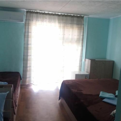 a bedroom with a bed and a large window at Отдых на Балхаше in Balqash