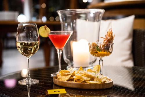 two glasses of wine and chips on a table at Hotel Isola Sacra Rome Airport in Fiumicino
